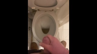 a guy pisses and then masturbates in the bathroom, cumming with his nice cock all over the place